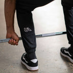 Unconditional Active Warlock Long Jogger trackpants in black with elastic waistband and tapered fit, casual athletic wear.